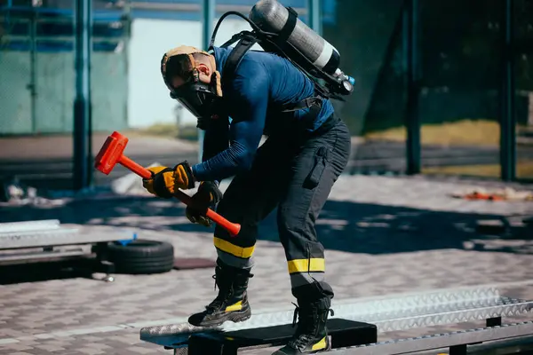 Храбрый Пожарный Тренируется Кислородным Баллоном Молотком Спортивной Площадке Лицензионные Стоковые Изображения