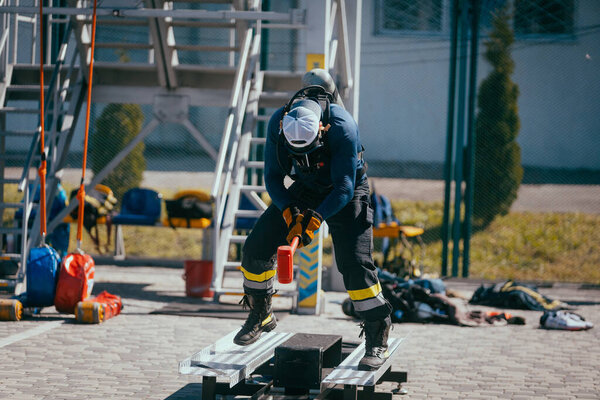 Male Firefighter Hammer Training Sports Ground Stock Photo