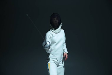 Siyah arka planda eskrim maskeli, beyaz eskrim kıyafetli bir adam.