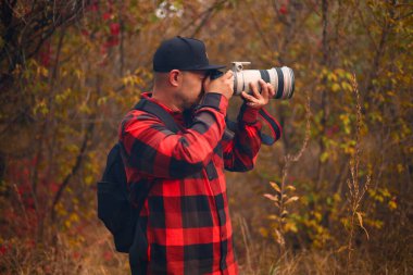 Orman arka planında kamerası olan bir adam.
