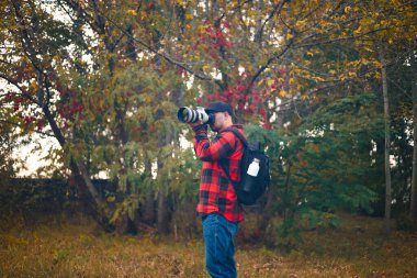 photographer takes pictures in the autumn forest