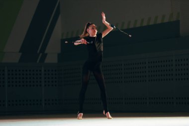 Ritmik jimnastikçi kız spor salonunda antrenman yapıyor..