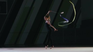 Ritmik jimnastikçi kız spor salonunda antrenman yapıyor..