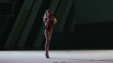 Ritmik jimnastikçi kız spor salonunda antrenman yapıyor..