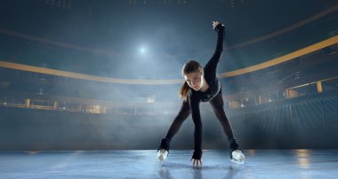 Artistik patenci kadın buz stadyumunda kayıyor..