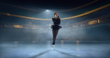 Artistik patenci kadın buz stadyumunda kayıyor..