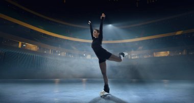 Artistik patenci kadın buz stadyumunda kayıyor..