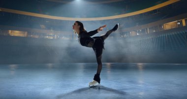 Artistik patenci kadın buz stadyumunda kayıyor..