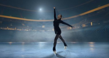 Artistik patenci kadın buz stadyumunda kayıyor..