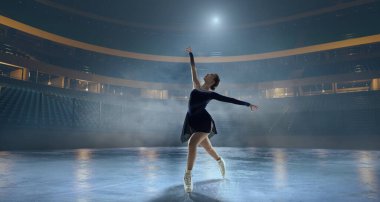 Artistik patenci kadın buz stadyumunda kayıyor..
