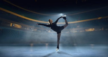 Artistik patenci kadın buz stadyumunda kayıyor..