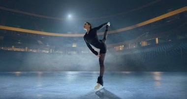Artistik patenci kadın buz stadyumunda kayıyor..
