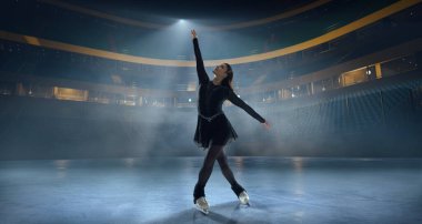 Artistik patenci kadın buz stadyumunda kayıyor..
