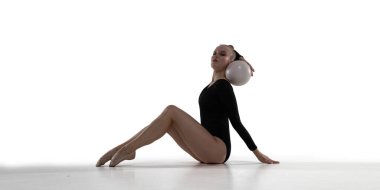 Beyaz arka planda ritmik jimnastik yapan kadın..