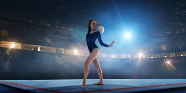 Geceleri profesyonel 3 boyutlu jimnastik stadyumundaki ritmik jimnastik kızı.