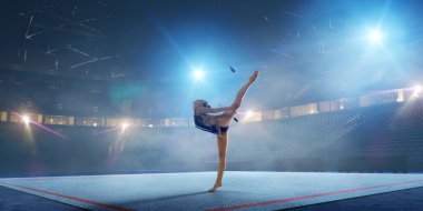 Geceleri profesyonel 3 boyutlu jimnastik stadyumundaki ritmik jimnastik kızı.