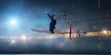 Geceleri profesyonel 3 boyutlu jimnastik stadyumundaki ritmik jimnastik kızı.