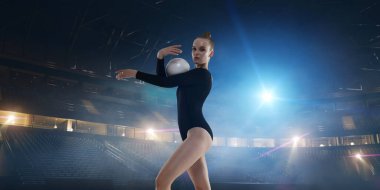 Geceleri profesyonel 3 boyutlu jimnastik stadyumundaki ritmik jimnastik kızı.