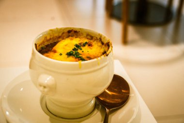 Geleneksel Fransız Soğan Öğütücü Çorbası beyaz bir porselen kasede