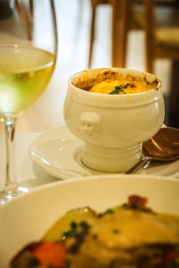 Geleneksel Fransız Soğan Öğütücü Çorbası beyaz bir porselen kasede