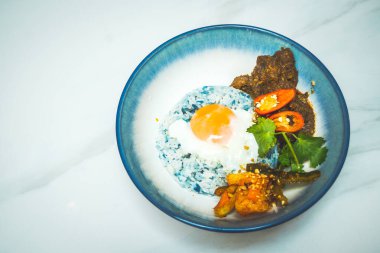 Bir kase sığır eti rendang pilavı sığır eti rendang cuves, kelebek bezelye pilavı, güneşli tarafı yumurta ve turşu turşusu.