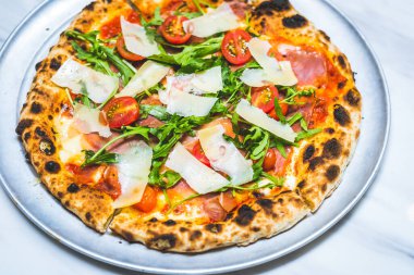 Peynirli, patma jambonlu, roka soslu, domates soslu ve vişneli pizza.