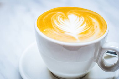 Süt köpüklü latte sanatı, süt ve espresso beyaz porselen bardakta.
