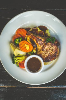 Domuz pirzolasında 300 gm 'lik leziz kemik patates püresi, tereyağlı sebze ve ev yapımı LP sosuyla servis edilir.