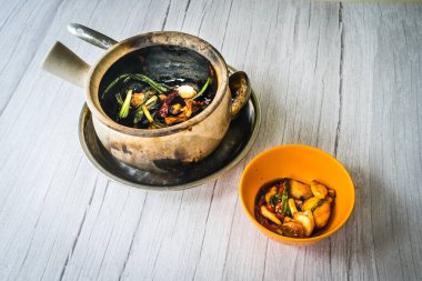 Kızarmış kurbağa bacağını taze soğanla karıştır ve kurutulmuş kamış biberi ile maydanozda servis et.