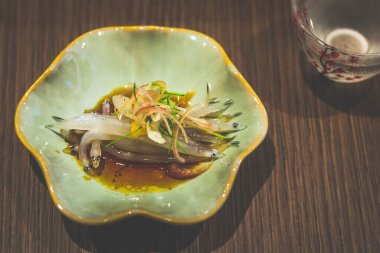 Japon beyaz yem balığının aperatifleri küçük bir tabakta servis edilir.