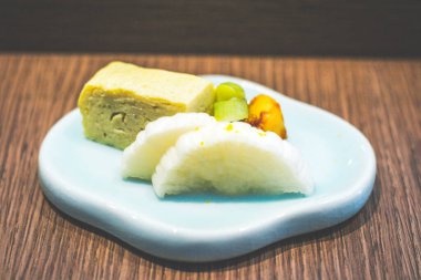 Küçük bir tabakta servis edilen küçük bir porsiyon Japon turşusu ve turşu yumurtası.