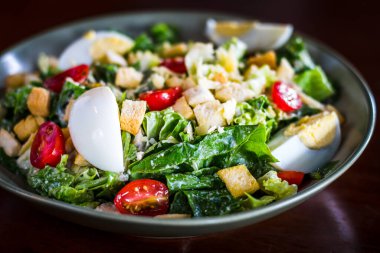 Sezar salatası, ızgara tavuk göğsü, kızarmış ekmek, haşlanmış yumurta ve vişneli domates.