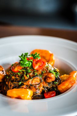 Baharatlı deniz ürünleri spagettisi Aglio Olio mürekkepli spagetti.