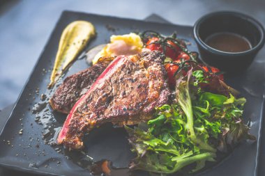 NZ pirzola bifteği, tavada az pişmiş, yanında gerçek köy kremalı patates püresi, sarmaşıklı vişneli domates, salata.