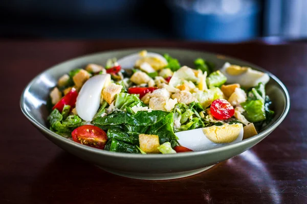 Sezar salatası, ızgara tavuk göğsü, kızarmış ekmek, haşlanmış yumurta ve vişneli domates.
