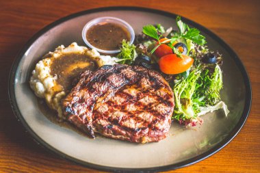 Patates püresi ve soslu biftek, salata ve mantar sosu.