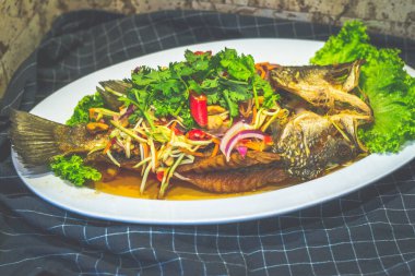 Kızarmış deniz kabuğu mango salatasıyla ezildi ve tabakta servis edildi.