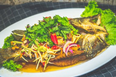 Kızarmış deniz kabuğu mango salatasıyla ezildi ve tabakta servis edildi.