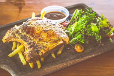 Yanında salata ve sos olan Cajun Rosemary Pork Chop.