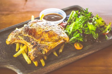 Yanında salata ve sos olan Cajun Rosemary Pork Chop.