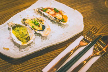 Izgara istiridye, içinde sarımsaklı ESCARGOT Butter, panko & maydanoz, kırmızı miso bechamel ile MISO GRATIN, emmental peynir & negi, domatesli MARGHERITA, mozzarella & fesleğen