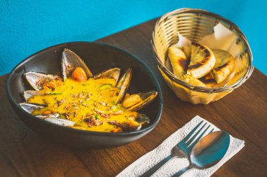 Kavanozda körili midye ve pide ile servis edilir.