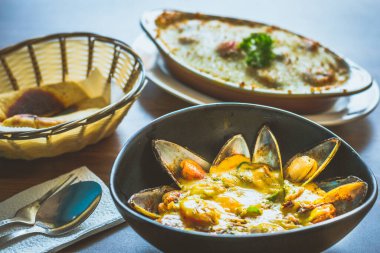 Kavanozda körili midye ve pide ile servis edilir.