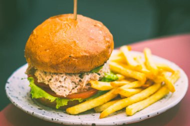 Hafif mayonezli buğulanmış kar yengeci, üstüne guacamole sosu, kızarmış soğan, kıvırcık salata ve domatesli çörek.