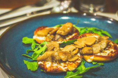 Kiraz, domuz eti ve tavada kızartılmış Scarmoza peyniri ile birlikte tüttürdü. Roka ile servis edilir.