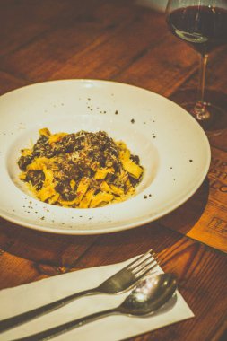 Böcek kıymalı TAGLIATELLE makarnası. Kırmızı şarap sosunda yavaş pişirilmiş.