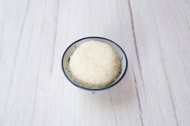 Masadaki kasede servis edilen bir kase beyaz pirinç.