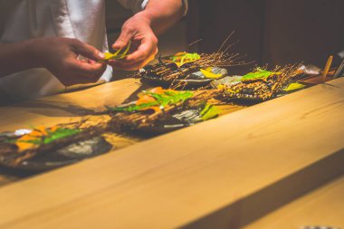 Japon bir aşçının elleri bir kaiseki omakase restoranında yemek hazırlıyor.