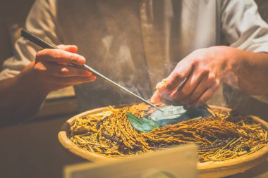 Japon bir aşçının elleri bir kaiseki omakase restoranında yemek hazırlıyor.