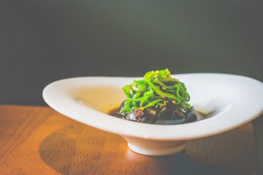 Beyaz tabakta servis edilen ızgara biberli yüzyılın dilimleri.